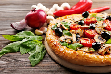 Delicious tasty pizza with ingredients on wooden table