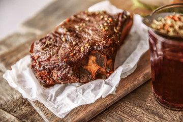 Roasted pork steak with wineglass  and spices on wooden background