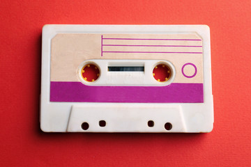 Old audio cassette on red background