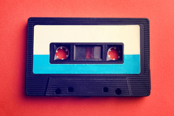 Old audio cassette on red background