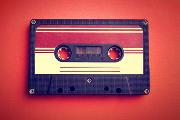 Old audio cassette on red background