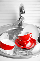 Pile of dishes in sink closeup