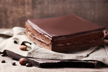 Delicious chocolate cake with coffee beans on wooden background
