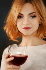 Young woman with glass of red wine closeup