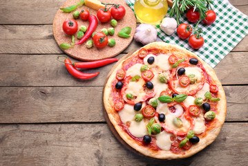 Delicious pizza with cheese and vegetables on wooden background