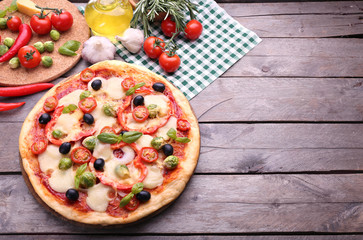 Delicious pizza with cheese and vegetables on wooden background