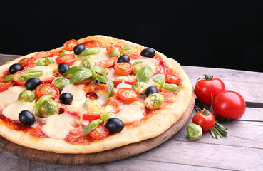 Delicious pizza with cheese and vegetables on black background