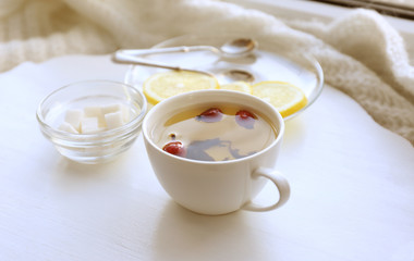 Tea set on a white wooden tray on the windowsill