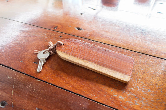 Blank wood tag and keys on wooden table, selective focus