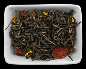 Dry tea leaves in bowl, isolated on white