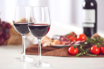 Glasses of red wine with food on table closeup