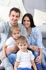 Obraz premium Happy family sitting on floor on couch background, closeup