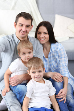 Happy family sitting on floor  on couch background, closeup
