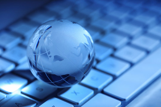 Crystal globe on laptop keyboard,  close up