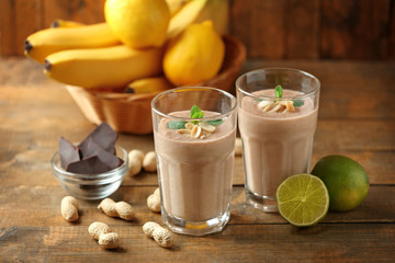 Fototapeta premium Fresh banana cocktail with peanuts and chocolate on wooden table