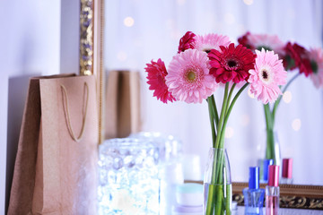 Bouquet of fresh gerbers in vase in front of the mirror indoors