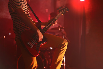 Man playing electric guitar on a stage.