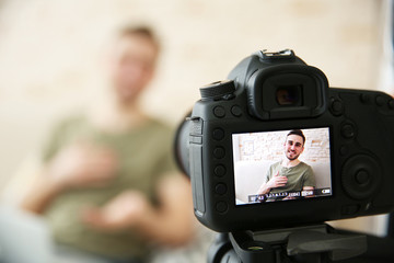 Young male blogger on camera screen