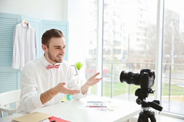Young male blogger recording video at home