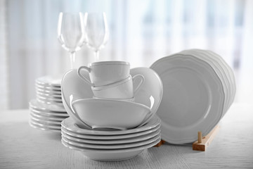 Set of new white dishes on wooden table, indoors