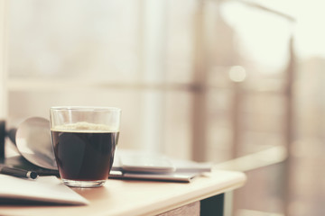 Cup of coffee and notebook on the table in cafe