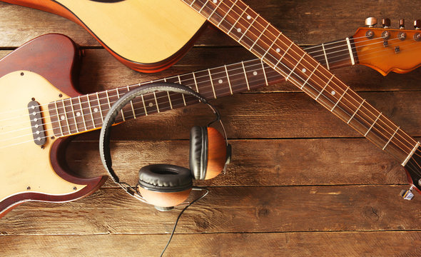 Guitars and headphones on wooden background
