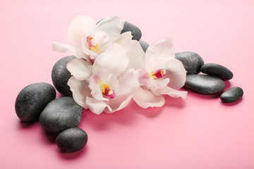 Obraz na płótnie Canvas Spa stones and white orchid on pink background