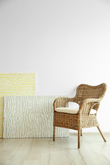 Wicker chair on light wall background