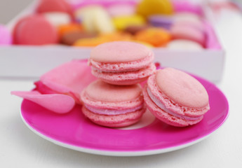 Fresh macaroons on pink plate, closeup