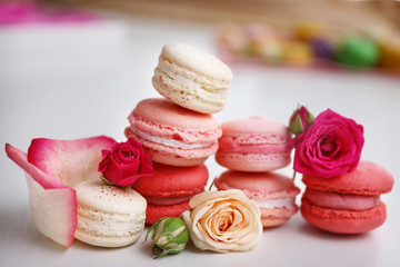 Macaroons with roses on white background