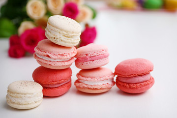 Macaroons with roses on white background