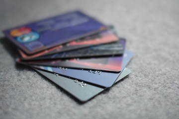 Colorful stack of credit cards and shopping gift cards on gray c