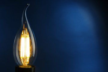 Illuminated light bulb on dark blue background