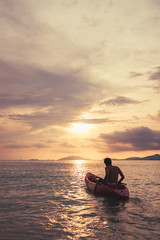 a guy on kayak boating to sunset, vintage tone, abstract concept 