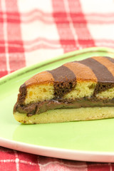 Triangular chocolate cake on green triangular plate