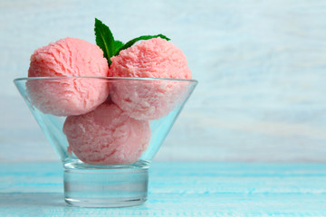 ice cream with mint in bowl on wooden background