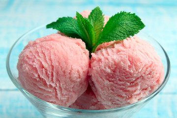 ice cream with mint in bowl on wooden background