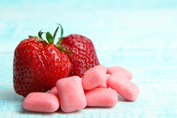 chewing gum and strawberry on wooden background