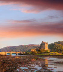 Naklejka na ściany i meble Eilean Donan Castle against sunset in Highlands of Scotland