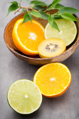 Naklejka na ściany i meble Mixed citrus fruit lemons, orange, kiwi, limes on a gray backgro