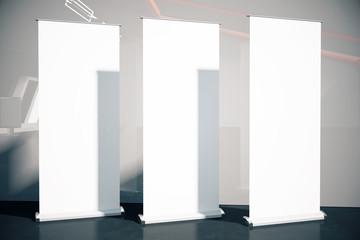 Three posters on grey wall