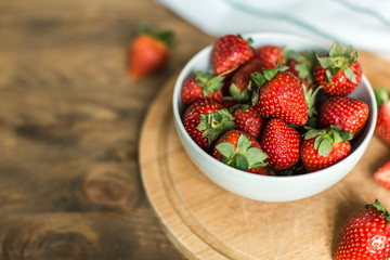 ripe strawberries on plate on wooden background