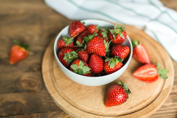 ripe strawberries on plate on wooden background