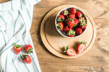 ripe strawberries on plate on wooden background