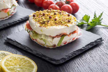 Tortino di formaggio cremoso  e salmone affumicato su piatto di ardesia ambientato 