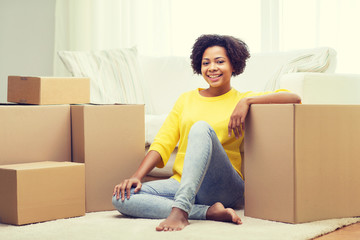 happy african woman with cardboard boxes at home