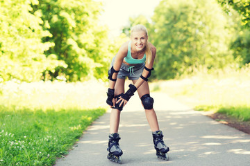 Fototapeta premium happy young woman in rollerskates riding outdoors