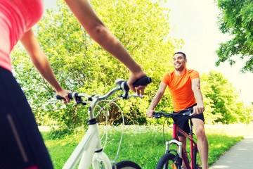 close up of happy couple riding bicycle outdoors