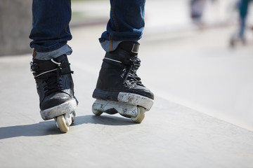 Feet of aggressive inline rollerblader on outdoor skatepark