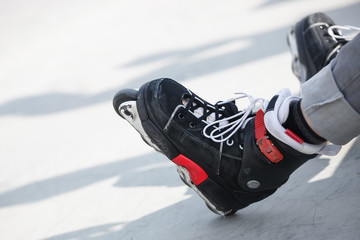 Aggressive inline rollerblader sitting on ramp in skatepark